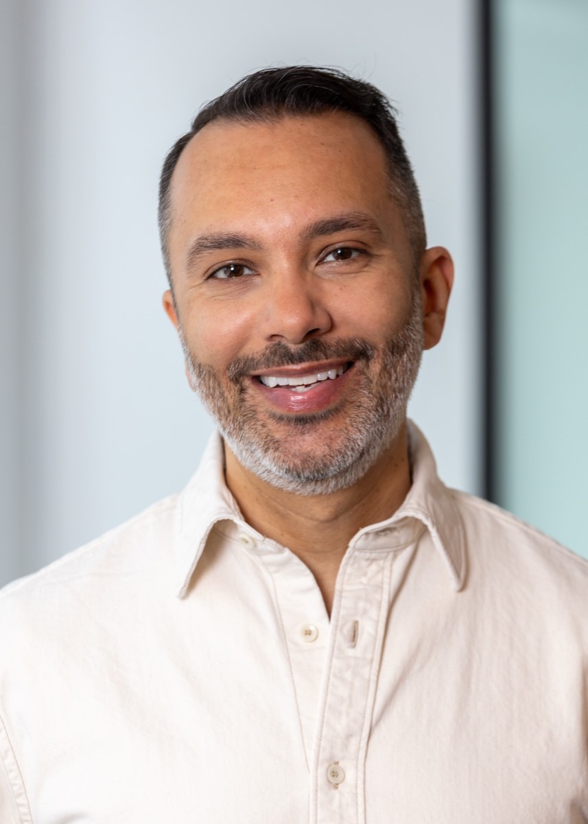 Portrait of a man with a grey beard in a cream shirt