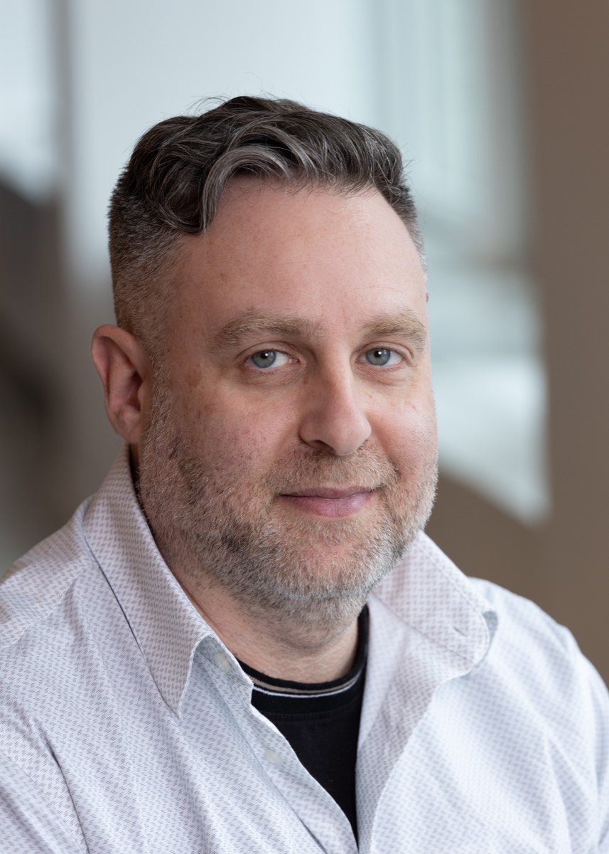 Portrait of a man with a beard in a white patterned shirt